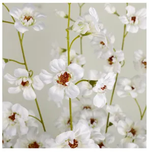 Artificial white silk flower detail shot, delicate petals and green stem, perfect photography prop.