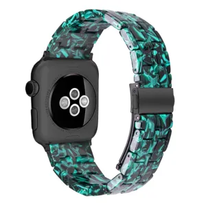 Resin watch band close-up showing black and green marble texture and metal folding clasp.