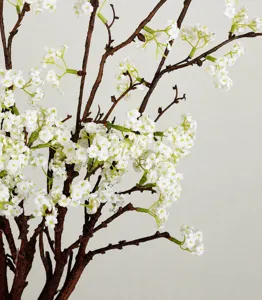 Primo piano dettagliato di un ramo di fiori di salice bianco artificiale, decoro realistico.