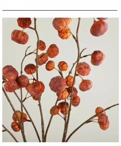 Artificial pumpkin fruit branch close up, realistic foam floral decor for table display.