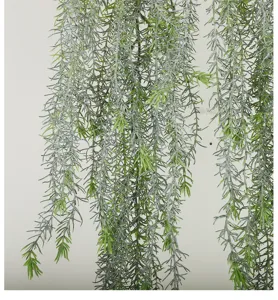 Artificial hanging plant detail, frosted green pine needle vine for wall decoration setup.