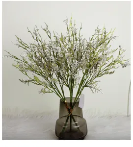 Detailed view of artificial lover's grass in a stylish grey glass vase, home decor close-up