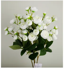 Close-up detail of white artificial tea rose bouquet flower buds with green leaves decoration.