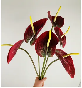 Artificial anthurium flower detail showing realistic red texture, flexible stem and yellow spadix.