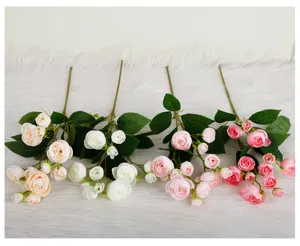 Detailed view of 12-head artificial tea rose flower branches with green leaves, close-up.