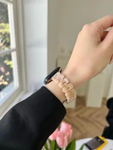 Detailaufnahme des stilvollen Blüten-Resin-Ersatzarmbands für die Apple Watch am Handgelenk.
