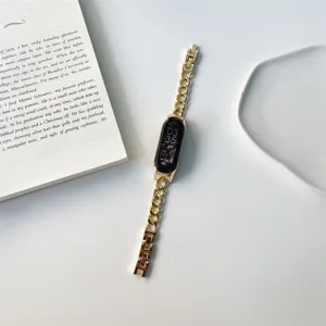 Primo piano dettagliato di un cinturino a catena in metallo dorato per fitness tracker.