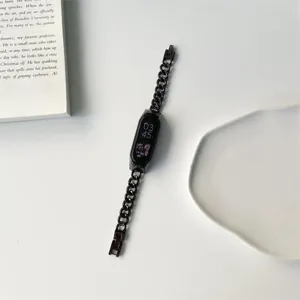 Dettaglio del cinturino a catena in metallo nero per smart band su sfondo minimal.