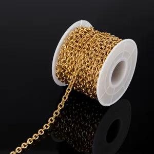 Close-up detail of golden stainless steel cable chain on white spool for DIY jewelry making.