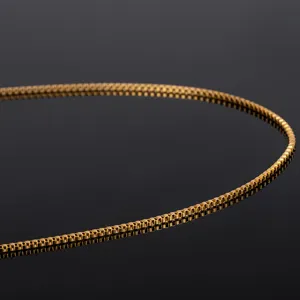 Primer plano de una cadena cuadrada de acero inoxidable dorado, ideal para joyas y collares.