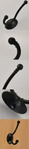 Detailed view of black metal coat hook, showing curved double hook and mounting base design.