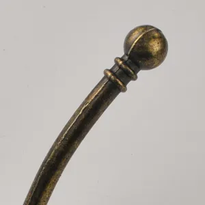 Close-up detail of European antique style bronze metal hook with spherical top and ring design.