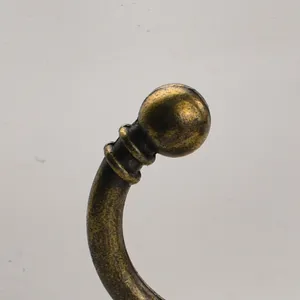 Antique brass finish metal coat hook detail view, elegant vintage furniture hardware component.