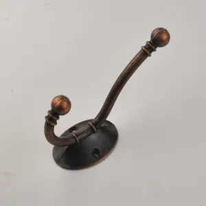 Detailed shot of retro bronze metal double coat hook, showing vintage texture and fix holes.