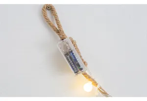 Detailopname van de batterijhouder van creatieve LED-lichtketting en hennepkoord op muur.