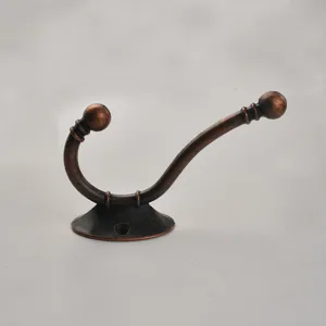 Detailed closeup of an antique bronze double coat hook, retro wall mounted hardware for home decor.