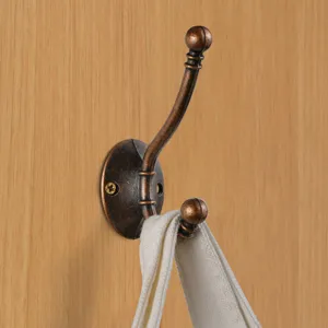 Retro bronze wall mounted double clothes hook for cabinet door and entry hallway use.