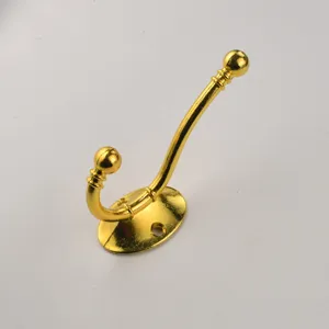 Gold metal wall coat hook detail, vintage double prong design, durable hardware fixture.