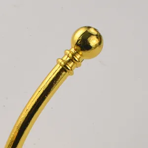 Gold metal hardware detail shot showing the ball end knob of a decorative coat hook or handle.