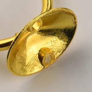 Close-up detail view of golden metal hardware hook mounting base with double screw holes.