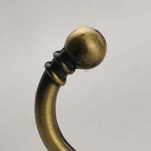 Close up detail view of the retro brass antique coat hook showing the smooth curved brass design.