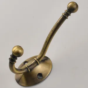 Vintage brass double coat hook wall mounted antique metal clothes hanger hardware detail shot