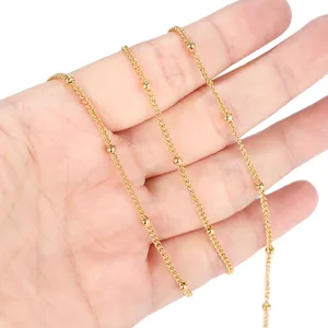 Vue detaillee en gros plan d'une chaine a billes satellite en acier dore pour bijoux.
