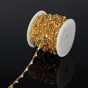 Detailed close-up of gold stainless steel heart chain on spool for DIY jewelry making.