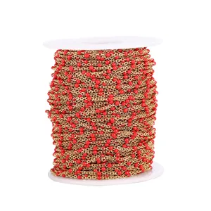 Detailed view of gold-tone stainless steel chain with vibrant red enamel beads on white spool.