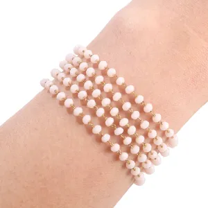 Detailed close-up of a multi-strand pink crystal beaded bracelet wrapped around wrist.