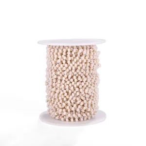 Detail shot of light pink crystal glass bead chain on spool for DIY jewelry making accessories.