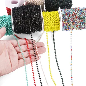 Close-up of colorful crystal glass bead chains on spools for DIY jewelry accessories detail.