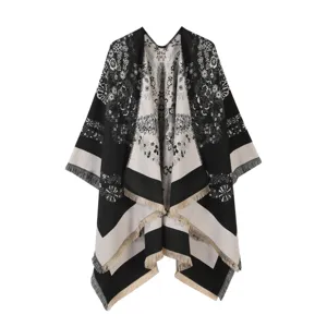 Close-up detail of women winter warm floral cape, black and white shawl with chic fringe edge.