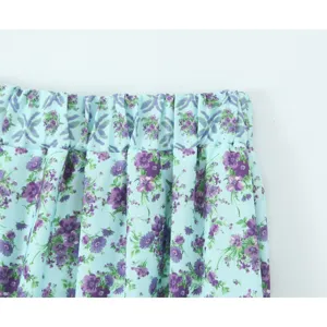 Detailaufnahme eines Retro Blumen Midirocks mit elastischem Bund und blauem Stoff.