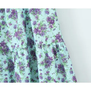 Detailaufnahme des hellblauen Stufenrocks mit elegantem lila Blumenmuster bedruckt.