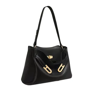 Sac à bandoulière en cuir noir avec fermeture à verrou métallique doré et détail d'arche.