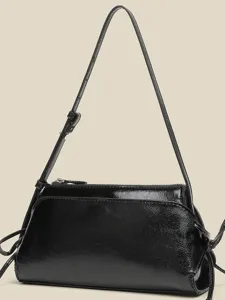 Schwarze Lackleder-Minischultertasche mit seitlichen Schleifen, kompaktes und stylisches Design.