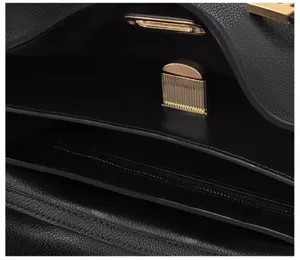Vue détaillée de l'intérieur du sac à main en cuir noir avec fermoir métallique.