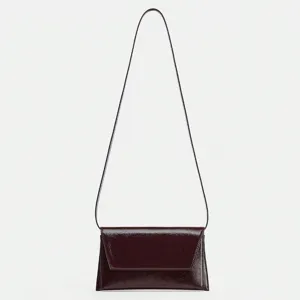 Vue détaillée du sac bandoulière élégant en cuir verni doté d'une très fine lanière.