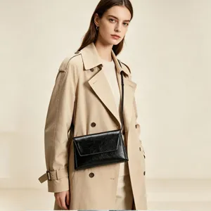 Sac à bandoulière noir minimaliste pour femme, élégant design à rabat pour le travail quotidien.