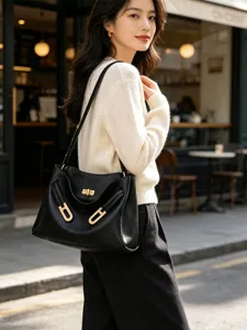 Détail du sac à main noir avec fermoir tournant métallique et bandoulière élégante.