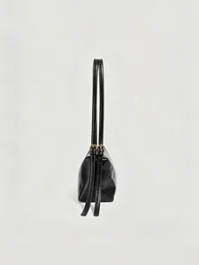Vue détaillée latérale d'un sac à épaule minimaliste noir brillant avec de fines lanières.