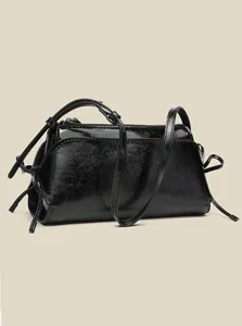 Schwarze glänzende Lackleder Mini Schultertasche Detail, elegante Schleife und Reißverschluss.