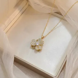 Elegante collar con colgante de trébol de cuatro hojas dorado con circonitas.