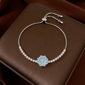 Preciosa pulsera plateada ajustable con una flor de esmalte azul y circonitas brillantes.