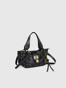 Détail du sac porté épaule en cuir noir avec cadenas vintage, clous et ferrures.