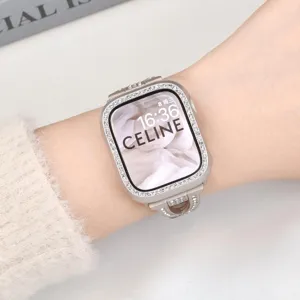 Detailaufnahme des Strass-Uhrengehäuses mit funkelnden Kristallen am silbernen Rahmen am Handgelenk.