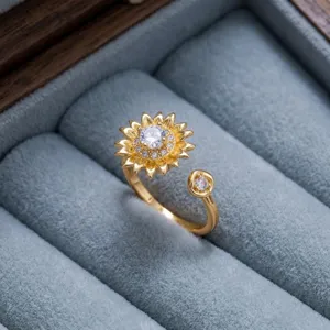 Detalle exquisito del anillo abierto de girasol dorado con brillantes piedras de circonita.