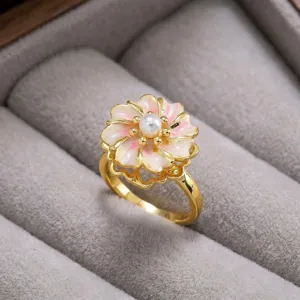 Anillo de flor dorada con perla y pétalos de esmalte rosa, elegante accesorio.