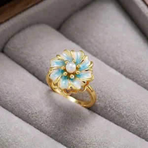 Vista de primer plano detallada de un elegante anillo floral dorado con pétalos esmaltados.